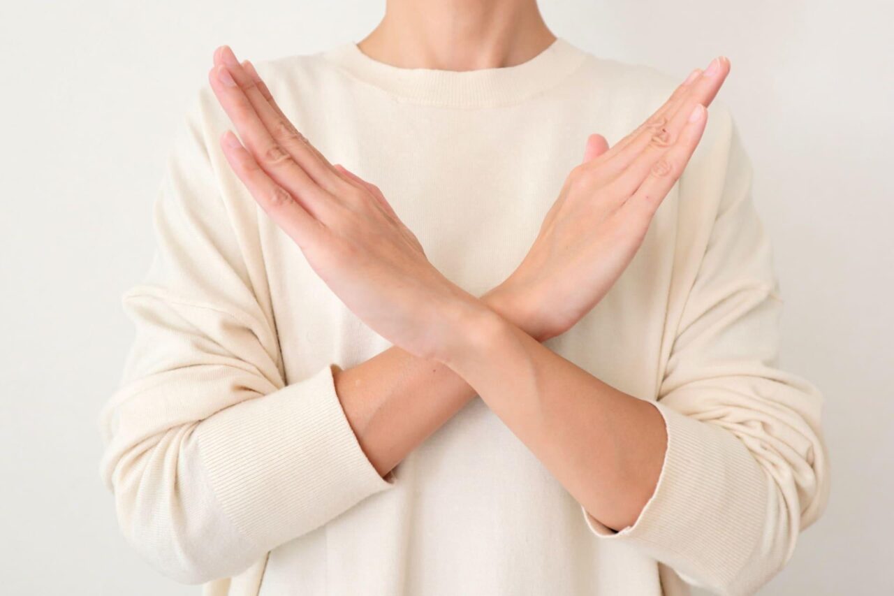 両腕を胸の前で交差させてバツ印を作る人